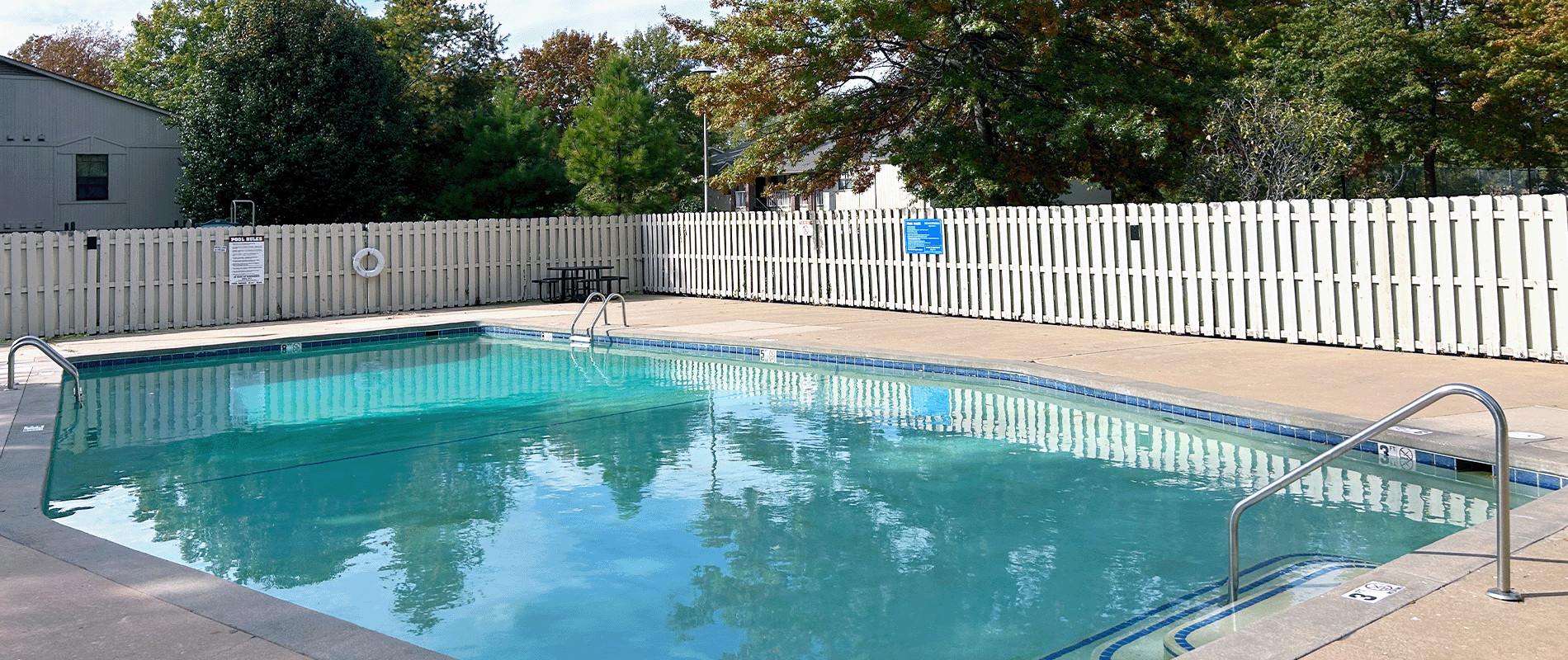 A small pool surrounded by a white fence.
